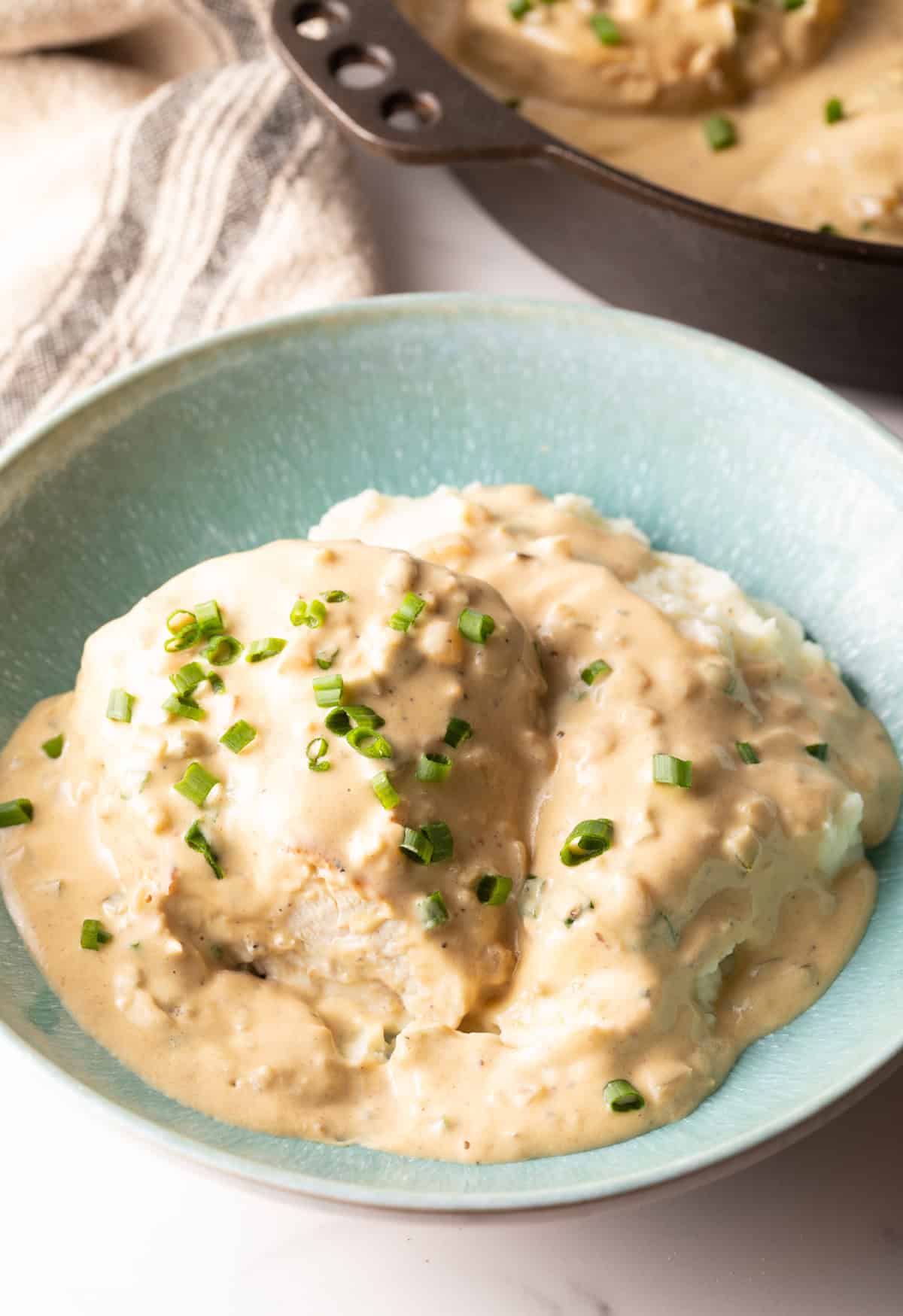 Sinine kauss, mis on täidetud kreemja jalapeno kanaga ja mille peal on roheline sibul.